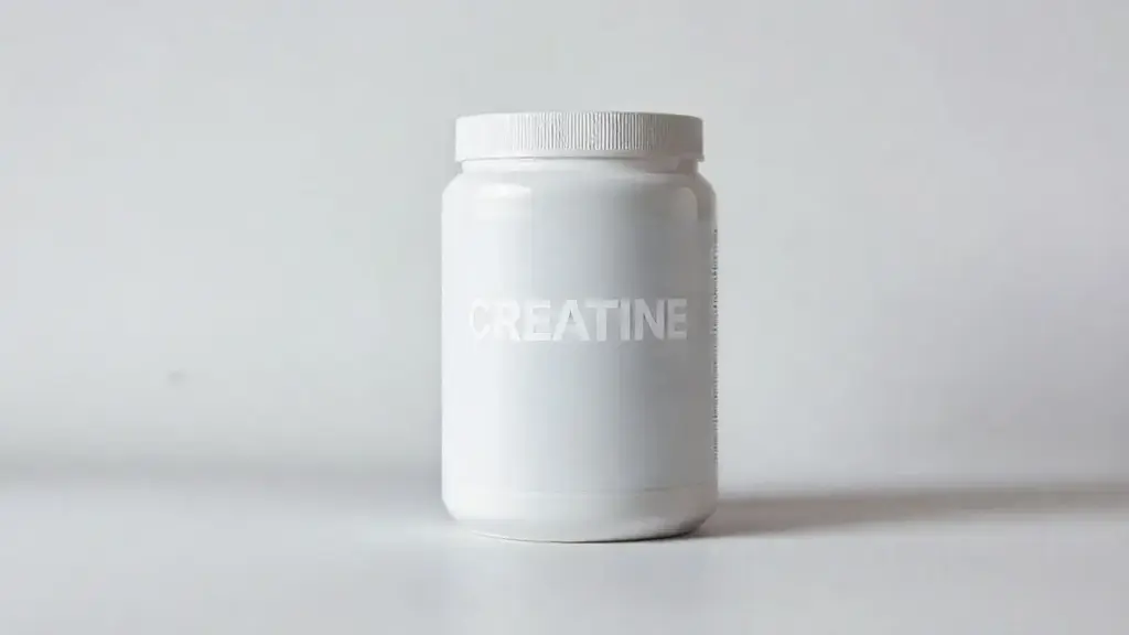 Pote de creatina em pó totalmente sem marca sobre uma superfície elegante, ilustrando os benefícios do suplemento para o corpo feminino.