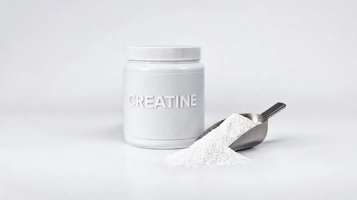 Pote de creatina sem marca e um medidor com o pó branco do suplemento em um fundo limpo de estúdio, representando um guia sobre a melhor creatina.