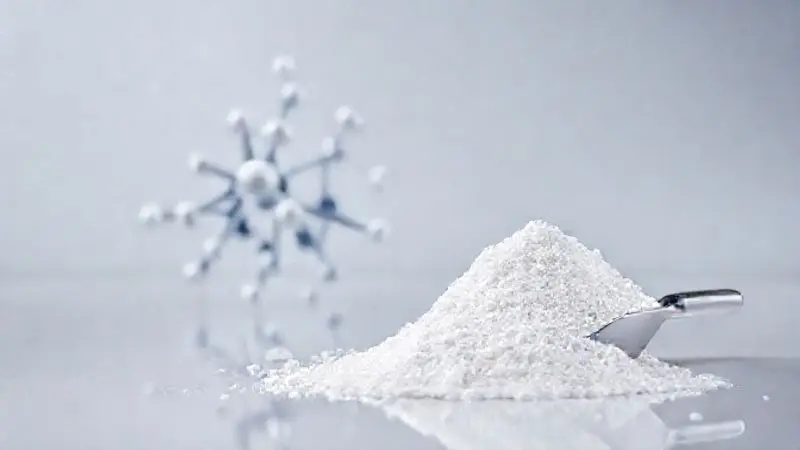 Ilustração da estrutura molecular da creatina ao lado de um dosador com o pó branco, explicando o que é e para que serve o suplemento.