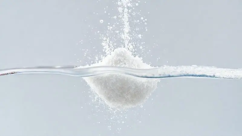 Ilustração conceitual da solubilidade da creatina em água com partículas dispersando uniformemente